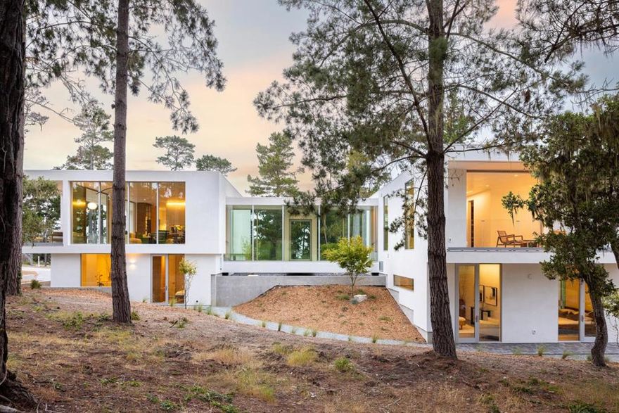 With sweeping views of Spyglass Hills 11th fairway and filtered ocean vistas, the Waterbridge House is an extraordinary Scandinavian-Japanese minimalist estate. This newly constructed compound is comprised of the stunning main house, a private ADU, and a Tea House (Guest House) floating on water. The striking architecture embraces intentional simplicity, blending natural elements with modern form. Two architectural axes, interior and exterior, guide you through spaces that reveal and conceal, including the "Waterbridge," a glazed walkway over a tranquil pond. The sculptural Cloud Steps lead to a light-filled interior where polished concrete floors, Western floor-to-ceiling windows, Italian concealed Infinity doors, and Poliform cabinetry define quiet luxury. Sustainability meets sophistication with triple-glazed windows, radiant heat, and an automated energy recovery system. From Sub-Zero, Wolf, and Miele appliances to Italian Flos lighting and Simply White plaster walls, every detail reflects enduring craftsmanship and environmental mindfulness. Located in the heart of Pebble Beach near The Lodge and by the Spyglass Club House, Waterbridge House is a half mile to the beach and a short drive from all the wonderful amenities of Carmel, Big Sur, and the Monterey Peninsula.