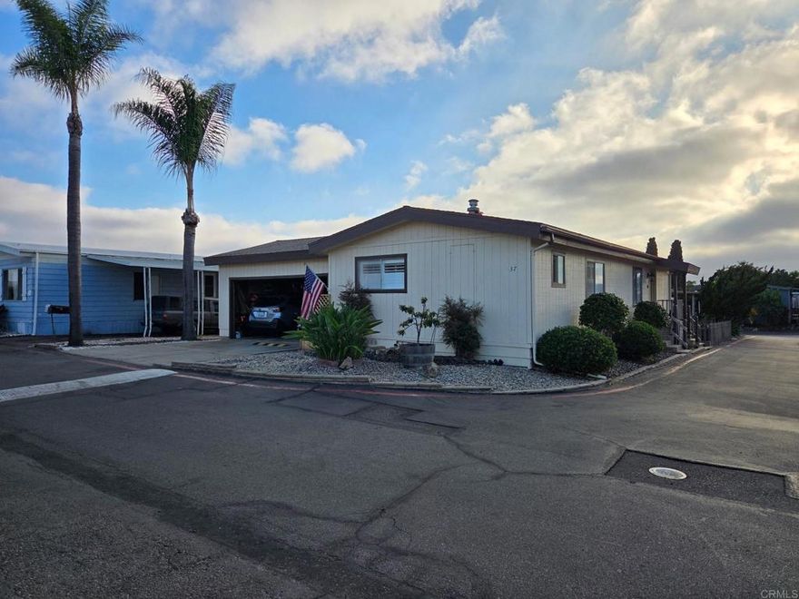 Open house Saturday October 18, 2025, 12 to 3.  Make an offer for this beautiful corner home locate at the top of the park with the best breeze in Tiki Village, a premier all-age mobile home community. Well maintain home with newer upgrades. Enchanting view of the Polynesian Style Clubhouse with tropical grounds, heated pool/spa, Tiki Room/grilling area and Billiards. Home has two car garage, private outdoor covered patio with 380 sqft, raise garden. sliding glass doors to back porch and patio. Efficient kitchen with pantry and granite counters. Textured walls, Plantation Shutters, mirrored closed doors. Low maintenance landscaping, exterior lighting, fenced outdoor area, raised garden beds, central AC/Heating. Pay NO property taxes, Low monthly space rent $874 at this time. Close to schools, shops, restaurants, theater, parks and freeway and a few minutes from the Pacific Ocean. Covered private patio is 380 sqft,