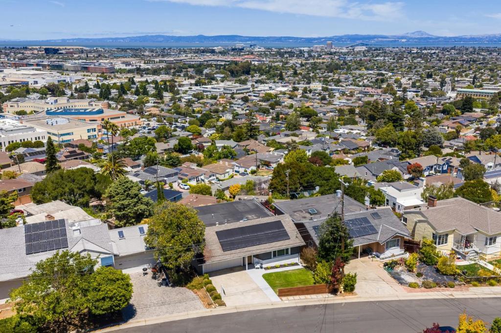 Commanding arguably the most extraordinary unobstructed bay views in all of San Mateo, this magnificent 4BR/4BA residence has been impeccably renovated to deliver a 3,580± SF immersive living experience where floor-to-ceiling vistas meet architectural sophistication. Plank and beam ceilings, oak floors, and refined moldings complement double-pane windows, skylights, and recessed lighting, illuminating integrated living spaces that flow onto a sprawling deck. Blending the warmth of natural wood with the elegance of stone, the chefs kitchen features granite countertops, custom cabinetry, premium appliances, a wine fridge, and a striking breakfast bar. Offering peaceful separation from the homes gathering areas, the main level also hosts a serene primary suite, a second bedroom, and a hall bath. Downstairs, a bedroom with a dedicated office provides the flexibility to create a luxurious secondary suite. A fourth bedroom, bonus room, and hall bath complete this floor. With its own full bath, washer/dryer, and seamless access to the newly completed backyard oasis, the lower level allows exceptional versatility, ideal for guest quarters, a family room, or a playroom. Additional highlights include solar panels, AC, and expansive storage. Unmatched, unrivaled, and unforgettable!