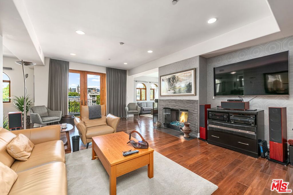 This exquisitely remodeled corner penthouse in a newer Mediterranean style building offers an unparalleled blend of refined elegance, comfort and sophistication, as well as gorgeous northeast facing views of city and skyline. This "developer's unit" boasts 3 bedrooms or 2 plus a den and 2.5 baths in approximately 1850 square feet all on one level. A gracious double door entry and expansive Anderson windows welcome you into an open and airy living space where high ceilings and rich wood floors create a peaceful, inviting ambience. A chic "designer perfect" powder room is tucked off the entry. Designed with both style and function in mind, the gourmet kitchen features top of the line Viking appliances and a Sub-zero fridge, Caesarstone countertops and custom cabinetry. The living and dining areas, enhanced by a custom designed stone fireplacethat adds warmth and character flow to a large front balcony. The serene primary suite offers a fireplace, luxe bath and generously sized walk-in closet. A spa like guest suite completes this wing of the unit. A spacious private rooftop deck with BBQ area offers breathtaking views, providing the perfect backdrop for entertaining or quiet relaxation. No expense was spared on the quality updates and finishes throughout which include imported wall coverings and Porcelanosa Spanish tile. Other highlights include recessed lighting, ample storage inside and out, secured side by side parking, plus guest parking, and low HOA dues. Ideally situated adjacent to Brentwood, Santa Monica and Westwood, this rare and special residence is truly a gem!