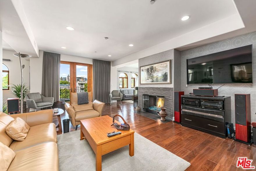 This exquisitely remodeled corner penthouse in a newer Mediterranean style building offers an unparalleled blend of refined elegance, comfort and sophistication, as well as gorgeous northeast facing views of city and skyline. This "developer's unit" boasts 3 bedrooms or 2 plus a den and 2.5 baths in approximately 1850 square feet all on one level. A gracious double door entry and expansive Anderson windows welcome you into an open and airy living space where high ceilings and rich wood floors create a peaceful, inviting ambience. A chic "designer perfect" powder room is tucked off the entry. Designed with both style and function in mind, the gourmet kitchen features top of the line Viking appliances and a Sub-zero fridge, Caesarstone countertops and custom cabinetry. The living and dining areas, enhanced by a custom designed stone fireplacethat adds warmth and character flow to a large front balcony. The serene primary suite offers a fireplace, luxe bath and generously sized walk-in closet. A spa like guest suite completes this wing of the unit. A spacious private rooftop deck with BBQ area offers breathtaking views, providing the perfect backdrop for entertaining or quiet relaxation. No expense was spared on the quality updates and finishes throughout which include imported wall coverings and Porcelanosa Spanish tile. Other highlights include recessed lighting, ample storage inside and out, secured side by side parking, plus guest parking, and low HOA dues. Ideally situated adjacent to Brentwood, Santa Monica and Westwood, this rare and special residence is truly a gem!