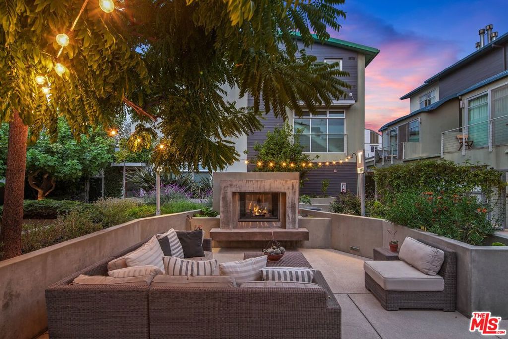 Nestled within a tranquil 6-unit enclave in the heart of Venice, this secluded 3-bedroom townhome seamlessly blends luxury with serenity. Its architectural charm reflects the area's distinctive artistic spirit, featuring French Oak floors and custom walnut cabinetry that evoke both warmth and sophistication. Sunlight streams through expansive windows, illuminating an inviting living space anchored by a cozy fireplace. The freshly renovated chef's kitchen showcases Viking appliances, CesarStone countertops, and a professional 6-burner stove. A unique bonus flex space features a roll-up door that opens onto a sun-drenched terrace, perfectly capturing Venice's eclectic energy. The primary suite occupies nearly the entire second floor, offering a light-filled sanctuary with a gas fireplace and private balcony for quiet Venice moments. The ensuite bath impresses with Axor fixtures, a Duravit soaking tub, and a sleek Caesarstone dual vanity. Two thoughtfully designed third-floor bedrooms showcase Venice artistry through custom Italian Murphy beds that maximize both comfort and space. A fully renovated Jack and Jill bathroom serves both rooms with style and functionality. The outdoor spaces invite both intimate and social moments. A private patio features a Lynx BBQ surrounded by fragrant jasmine, while the communal courtyard offers a built-in fireplace and BBQ area - perfect for gatherings under Venice's starlit sky. Modern conveniences include a secured direct-access 2-car garage and state-of-the-art fixtures throughout. When Venice beckons, Abbot Kinney Boulevard, Rose Avenue, and the Pacific's sandy shores await just steps from your door. This isn't simply a home. It's your Venice story waiting to unfold.