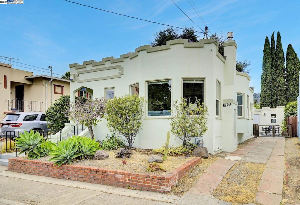 You won’t want to miss this charming 3 bed, 2 bath California bungalow, beautifully updated and full of character. An inviting front porch opens to an elegant entryway, leading into a bright living room with a cozy fireplace, built-ins, and an adjoining spacious dining area. The kitchen has been thoughtfully renovated with quartz countertops, subway tile backsplash, and a breakfast nook that doubles perfectly as a home office. The bedrooms are thoughtfully separated by a beautifully updated bathroom showcasing a stone countertop and classic penny tile flooring. Outside, the expansive backyard is perfect for entertaining and unwinding, complete with a generous deck and pergola, outdoor shower, raised garden bed, and fresh landscaping filled with native plants. A thriving vegetable garden promises a bountiful summer harvest, while a majestic oak tree offers natural shade and timel Additional highlights include a fully permitted ADU, ideal for guests, rental income, or extended family, plus owned solar panels to keep energy costs low. Located in Oakland’s desirable Millsmont/Frick neighborhood, with close proximity to the Laurel District, local hiking trails, and Mills College, this home is the perfect place to put down roots—truly move-in ready and waiting for its next owners.