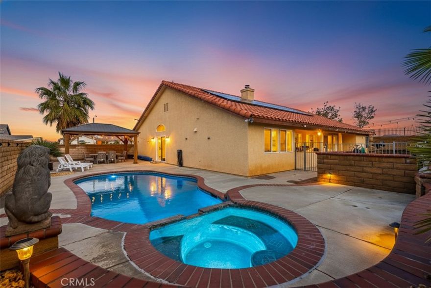 This stunning West Palmdale single-story pool home offers the perfect blend of comfort, style, and breathtaking valley views. Built in 2003 and ideally positioned on a **14,000+ sq ft corner lot at the end of a cul-de-sac**, this 4-bedroom, 3-bath residence is truly an entertainer's dream.

Step inside to find **beautiful neutral tile flooring** in the entry, kitchen, bathrooms, and laundry room, paired with **wood laminate flooring** in the halls and formal living and dining rooms. The **spacious family room** features a cozy fireplace with an elegant full wood mantle and raised hearth, creating the perfect gathering space.

The adjacent **gourmet kitchen** impresses with **quartz countertops**, rich alder cabinetry with glass-front accents, a **stainless steel 5-burner range**, and a custom vent-hood cover. Additional highlights include a built-in desk area, breakfast bar, and a generous dining nook overlooking the backyard.

The **primary suite** offers a peaceful retreat with a large walk-in closet complete with built-ins and direct access to the backyard. The **luxurious primary bath** features quartz countertops, a large jetted tub, separate his-and-hers sinks, and an oversized shower with designer tile. All guest bedrooms are generously sized and include ceiling fans. The guest bathroom features quartz countertops, a dual-sink vanity area, and beautiful tile finishes.

Step outside to your private oasis—**a sparkling built-in pool and spa**, spacious patio areas for entertaining, a grass yard, and a dedicated garden space. Additional features include a laundry room with a utility sink, a second utility sink in the garage, and a **leased 22-panel Zep Solar system** producing approx 12,000 kWh per year for energy efficiency for only $150 a month.

**Pride of ownership shines throughout—this home is a must-see!**
