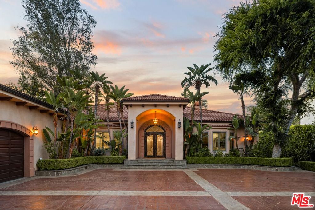 Welcome to 'La Dolce Vita!' A spectacular architectural Tuscan estate crowning a magnificent, near 30,000 sq.ft. private gated lot in one of the Valley's premier destinations. Set way back from the street, the home resides in divine harmony with its organic, verdant environment of towering trees and finely manicured fusion of floral and greenery. A grand entrance introduces a unique symmetry of old world essence with modern world conveniences with styling distinctive and comfortable; romantic and refined. Exemplifying bespoke craftsmanship at every turn, rich, luxurious elements reference classic design with a flexible floor plan offering gracious transition from room to room. Rich wood and exquisite tile flooring graces the living areas. Baths are dressed in fine tile, lighting and fixtures. The dining room lends itself ideally to both formal and informal gatherings. Style, form and function unite in the epicurean kitchen, adorned with top-of-the-line professional appliances. Glass atrium doors bring the outdoors in revealing an extraordinary, private oasis where an array of dining and lounging patios, full service outdoor kitchen and BBQ, fire pit lotus shaped pool and spa and sprawling lawns embody the coveted California lifestyle of endless al fresco leisure. The ideal venue for warm, relaxed poolside lounging by day, cool, intimate gatherings and lavish entertaining by night. Six bedrooms with seven baths including a lux primary suite with vaulted ceilings and walk in closet round out the comfortable accommodations. Highlights include a massive motor court and 6-car garage with soaring ceilings. Located in the acclaimed Chandler Elementary School District and just moments from the beloved Sherman Oaks Rec Center and Hazeltine Park. For those searching for that unique property with a vision toward a life well lived, this is the place where you want to reside. Welcome!