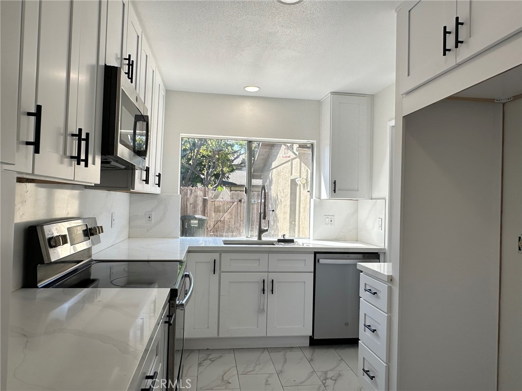 This is a pacious 3 bedroom 2 1/2 bath 2 story townhome. Home festures a private front courtyard and a private back yard patio. Recent ktichen make over with White shaker style cabinets topped with Quartz counters and full quartz backsplash. Warm rich laminated flooring throughout and primary suiet with carpet in secondary bedrooms. Living room includes a gas burning fireplace faced with travertine. Recessed lighting downstaris. Master bedroom includes a private bath and 2 closets. Inside laundry room is large enouth to use as a home office. Interior just painted. 1 car garage and assigned parkign spot. Foothill Townhomes also has a large pool area.