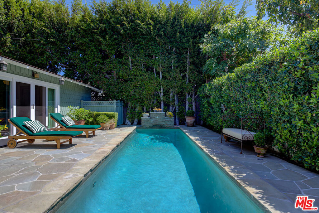 This charming gated bungalow home is surrounded by beautiful landscaping that offers both privacy and a tranquil setting for outdoor entertaining in prime Los Angeles, near the Sunset Strip and Hollywood. Immaculately presented, this 2-bedroom, 2-bathroom home comes with recently painted interiors and exteriors and includes a detached pool house with a private entrance, making it a perfect live-work option. Enter this charming home, and you'll feel welcomed right away. The open floor plan, featuring vaulted ceilings, leads you into a generously equipped kitchen, complete with everything a chef could need, and a dining room ready for hosting family and friends. Skylights provide lots of sunlight throughout the home. The Lounge/Living features a dramatic wood-burning fireplace. Adjacent to that is the perfect place for your evening cocktails. Dramatic doors slide open, leading you to a magical outdoor dining area and picnic spot with a stunning fountain. The primary bedroom has new wood flooring and French Doors that lead you to a dreamy outdoor European experience. The dressing area and primary bath will make you feel as though you are shopping in your closet! The guest suite also has its bathroom. Use your Pool House however you like, for a gym, home office, or separate entertaining area off the pool. The private backyard features a sparkling pool with a new pool heater. Every detail has been thoughtfully addressed with elegance and style. This is a Gem you will want to call home. Available Sept 1, 2025.