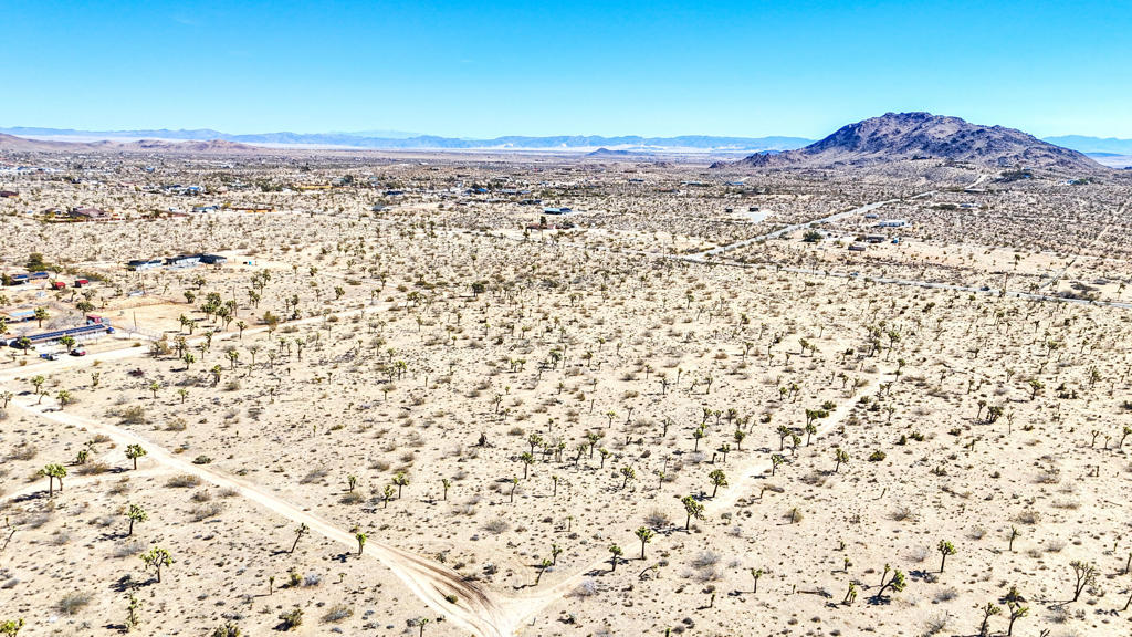 Embrace the beauty of the high desert on this exceptional 5-acre lot, just a short drive from Yucca Mesa Road. With expansive mountain views, a level terrain, and the tranquility of open space, this property is perfect for those seeking a peaceful retreat or a prime building site. There's ample room to design your ideal home, complete with a pool, garden, or guest house--whatever your dream entails!And if you dare to dream bigger, pick up the other 3 parcels, offering the opportunity to expand your estate to 20 acres by acquiring the neighboring lots. Whether you choose to develop now or invest in your future, this parcel is a prime opportunity in the growing Yucca Valley market. Photo with red outline is all 4, 5 acre parcels together. Other APNs available: 0598-084-31-0-000, 0598-084-32-0-000, 0598-084-34-0-000.