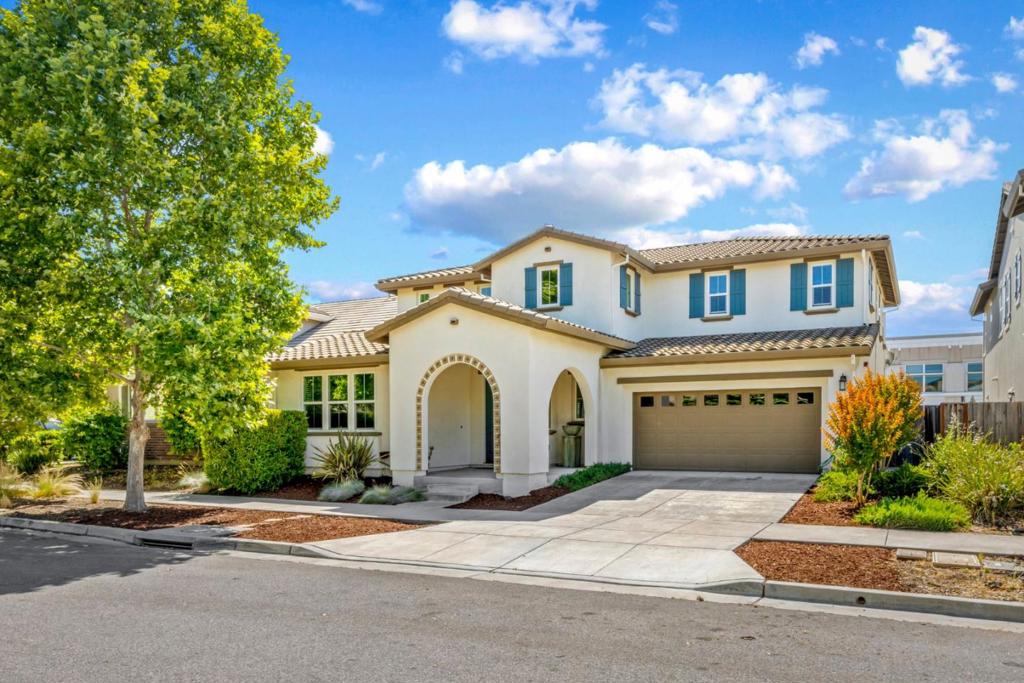 Spacious 4-bedroom, 3.5-bath home in a desirable Gilroy neighborhood near Christopher High School! With 3,065 sq ft of living space on a 7,020 sq ft lot, this 2-story home offers comfort and convenience. The first-level bedroom with ensuite is perfect for guests or multi-gen living. The open-concept layout features a gourmet kitchen, formal dining room, the living room has 4 hardwired Sonos speakers for surround sound entertainment, Step outside to a stunning California room with gas fireplace ideal for year-round entertaining, a stamped concrete patio and private hot tub retreat. The luxurious primary suite boasts two walk-in closets and a spa-like ensuite bath. Additional highlights include an upstairs flex space loft area, upstairs laundry, tankless water heater, extra-deep garage, and fully owned solar. Built in 2016, this home blends indoor luxury with outdoor enjoyment. A must-see!