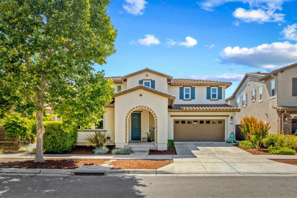 Spacious 4-bedroom, 3.5-bath home in a desirable Gilroy neighborhood near Christopher High School! With 3,065 sq ft of living space on a 7,020 sq ft lot, this 2-story home offers comfort and convenience. The first-level bedroom with ensuite is perfect for guests or multi-gen living. The open-concept layout features a gourmet kitchen, formal dining room, the living room has 4 hardwired Sonos speakers for surround sound entertainment, Step outside to a stunning California room with gas fireplace ideal for year-round entertaining, a stamped concrete patio and private hot tub retreat. The luxurious primary suite boasts two walk-in closets and a spa-like ensuite bath. Additional highlights include an upstairs flex space loft area, upstairs laundry, tankless water heater, extra-deep garage, and fully owned solar. Built in 2016, this home blends indoor luxury with outdoor enjoyment. A must-see!