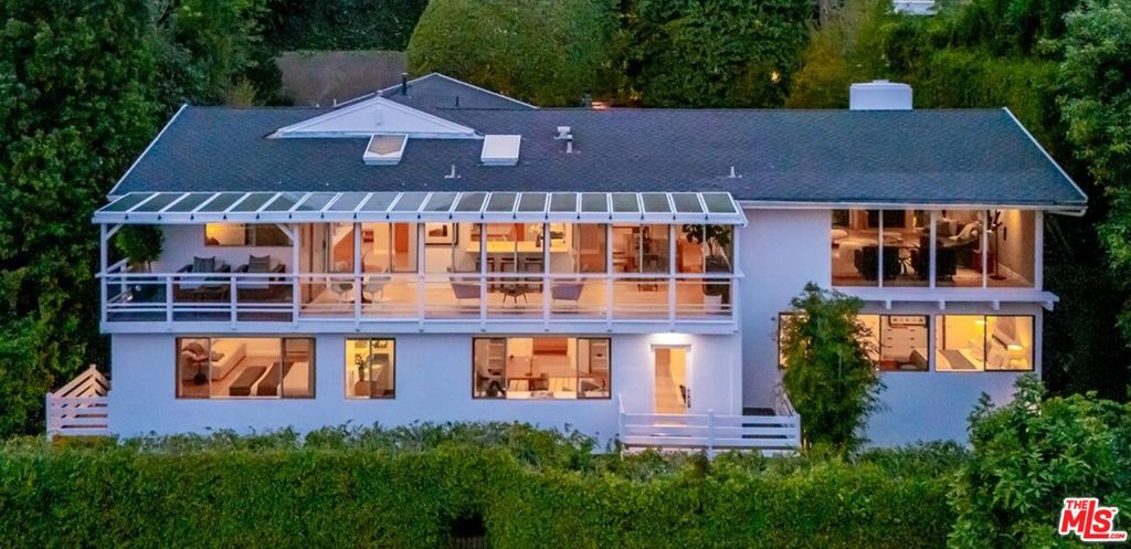 Iconic Mid-Century Post & Beam published Home with expansive hillside and city top views. Tucked behind gates in a serene, private setting just two minutes from Sunset Boulevard, this impeccably updated and expanded Mid-Century home offers the perfect blend of architectural integrity and modern luxury. Designed with timeless sophistication, this smart home showcases classic post-and-beam construction, soaring vaulted ceilings, and walls of glass that frame sweeping city and hillside vistas from nearly every room. The home's Zen-modern influenced landscaping creates a tranquil oasis, complete with a romantic pool and multiple outdoor entertaining areas. Inside, the sun-drenched living room centers around a marble-clad wood-burning fireplace, opening seamlessly to the surrounding views. A spacious dining area and a fully equipped chef's kitchen flow into a showstopping solarium glass-wrapped space perfect for casual dining and relaxed indoor/outdoor living. The main level includes a stylish media room, powder room, and a ensuite guest bedroom. A private primary suite that is a true sanctuary with dual bathrooms, dual walk-in closets, a cozy fireplace, a dressing area, and a private balcony. Two additional bedrooms, one currently configured as a library, along with a built-in office nook and a laundry room. Rare street to street property, beautiful living in the heart of the city!