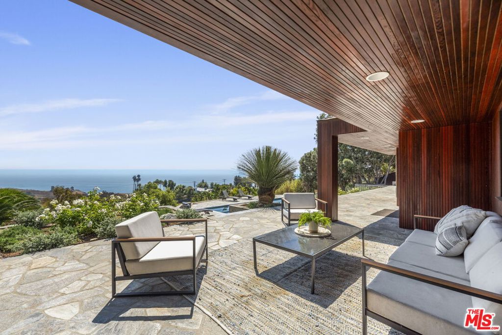 Stylish and sophisticated, this gated mid-century modern home has been beautifully remodeled with a designer's eye. Set on over an acre, the property is surrounded by lush landscaping and captures both stunning ocean views and peaceful canyon vistas.Inside, the home features dramatic high ceilings and a great sense of space, with clean lines and thoughtful finishes throughout and solar panels. Located on sought-after Carbon Mesa, it offers an effortless indoor-outdoor flow, perfect for entertaining. The newly redone pool and generous outdoor areas round out a home that's as comfortable as it is impressive.