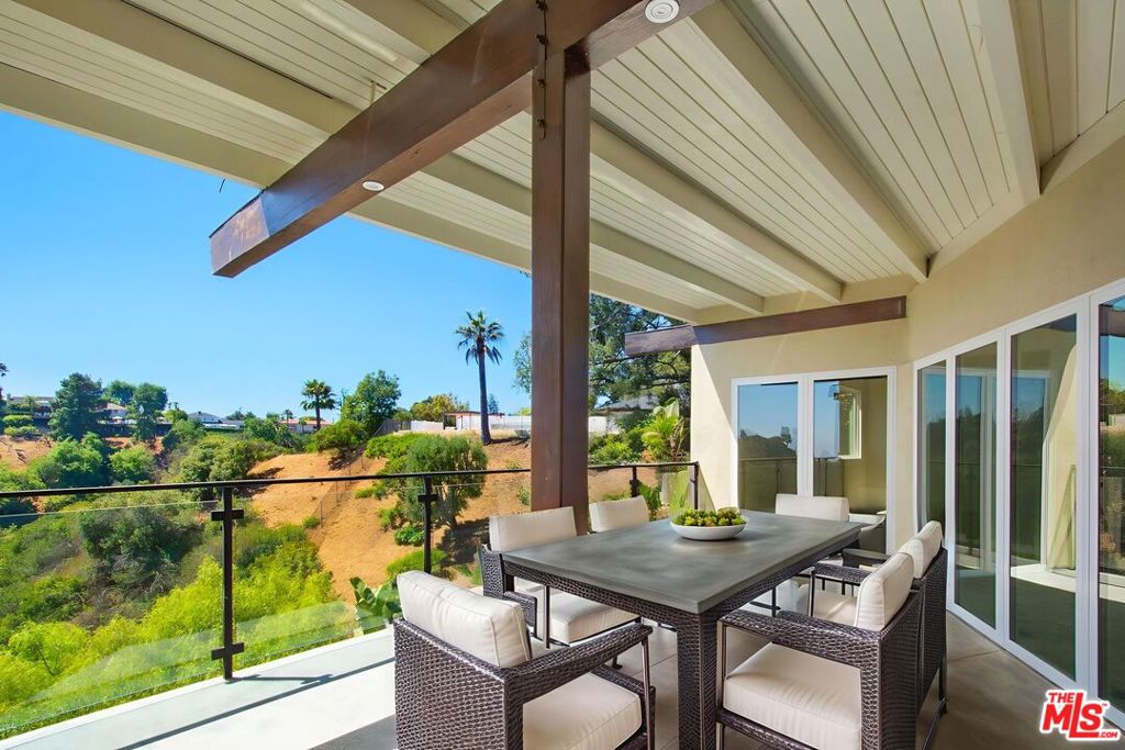 Welcome to this stylishly updated 3 bedroom, 2 bathroom home in Upper Bel Air, offering just under 1,900 square feet of thoughtfully designed living space. Surrounded by nature with canyon views, the home features a clean mid-century modern aesthetic with wide-plank oak style floors, oversized windows, and skylights that flood the space with natural light. The remodeled kitchen features quartz countertops, matte black hardware, a full suite of new appliances, and a wine cooler, perfect for easy entertaining. The spacious living room centers around a white brick fireplace and opens to a serene, covered patio with sleek glass railings and scenic hillside views. It's an ideal spot for relaxing, al fresco dining, or quiet mornings. The primary bedroom is a tranquil retreat with direct access to a peaceful outdoor setting and its own private patio. The en-suite bathroom is beautifully remodeled with dual sinks, quartz counters, and a separate glass-enclosed shower. The bathroom also opens to the patio, creating a seamless indoor-outdoor connection. Both bathrooms have been tastefully updated. A dedicated laundry room with a brand-new washer and dryer adds convenience to the home's functional design. An EV charger is also included, making it easy to power your electric vehicle at home. Located in a quiet Bel Air pocket with easy access to the Valley, Westside, and Roscomare Elementary, this home blends comfort, function, and design in a private, tranquil setting.