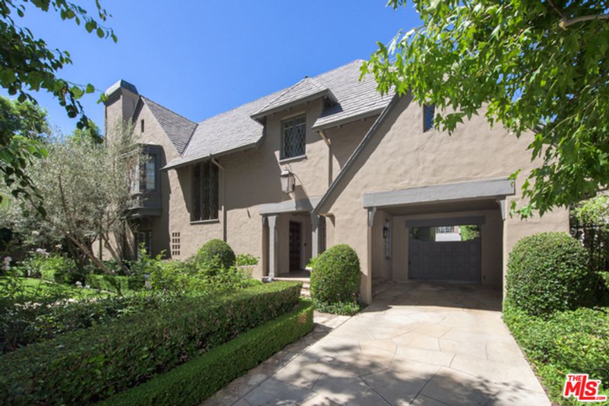 Fabulous French Country Estate with lush landscaping on the best street in Hancock Park! Step through verdant gardens via a covered entry with Porte Cochere into a welcoming two-story grand entrance hall with wrap around stairway. High ceilings and generous volumes define a view to the great living room and adjoining family room both with fireplace and windows looking on to green scapes. Enter the elegant formal dining room with large french doors and views of the private backyard with sculpted topiary, and a sparkling saltwater pool cited in a gorgeous garden surrounded by Magnolia trees, gardenias, and tall hedges. Outside, a pergola shades a romantic exterior dining area with outdoor fireplace. Upstairs are four bedrooms, a lovely master with a luxurious bath and an extra large closet. Also featured are two bedrooms downstairs, and a one bedroom detached guest house. Wonderful family home and a very rare offering.