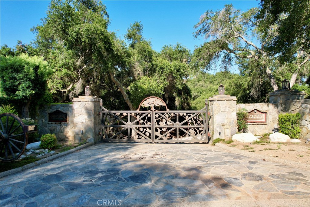 This enchanting 5.58-acre ranch is a testament to the culmination of years of artisanal expertise and creative flair. Whether one is seeking a tranquil retreat or a unique and unforgettable setting this treasure is sure to exceed expectations. As one meanders through this park like setting, you are drawn to the creative works by renowned artis Robert Morris with the custom gates to the stonework and 6x6 redwood fencing. All of the driveways are 6" thick that lead to the future building site. Retaining walls are in place for an approx. 6000 sq ft estate with plans available. Currently there are outlets and hook ups for a motor home. Soils test has been completed and power service is Edison 120 v service installed under-ground with breaker panel for 240v. District water and a well serve this parcel. Landscape lighting on timers line the many walking trails lined with stone work and pavers. Ornamental antiques, western wagons, tractors and a myriad of artistic items abound including a campsite with firepit, food prep and a serving area adjacent to the seasonal stream. The rolling lawns and ancient oaks also include 20 varieties of fruit trees to embrace this perfect setting. The collaboration of mother nature and man is as epic as the infrastructure being offered. Pictures do not do it justice.