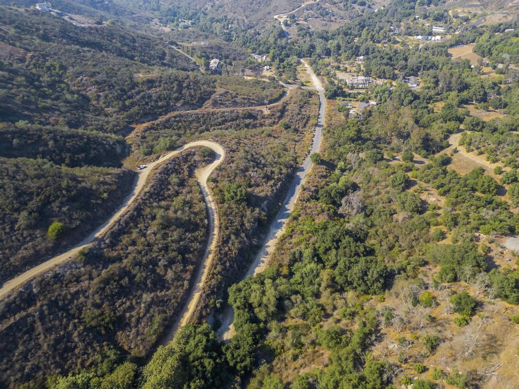 Welcome to your slice of paradise—15.7 acres of tranquil, buildable land nestled between Hidden Meadows and Valley Center, offering sweeping views of both Lake Turner and Mt. Palomar. This rare opportunity offers privacy, space, and incredible potential for a dream estate, horse ranch, or avocado farm. A 3-bedroom home has already been approved via plot map, making it easier to start building. The land is mostly usable, with approximately 2/3 of it level to gently sloped, and the remaining portion offering a steeper grade—ideal for scenic viewpoints or creative landscaping. Multiple Access Points: Easily accessible from several routes—via I-15 (Deer Springs exit/Mt. Meadows Road), from Valley Center (Lilac to Betsworth), or Escondido (North Broadway). Infrastructure Ready: Municipal water, electric, and fire hydrant are located at the edge of the property. Easements for the VCMWD and California Aqueduct mean existing utility roads can serve as convenient driveways. Prime Location: Surrounded by nature and luxury, with multiple golf courses and million-dollar homes within just 1 mile. This lot sits outside of any HOA and offers a rural lifestyle with city convenience just minutes away. Versatile Use: Whether you're looking to build a private estate, split into multiple lots, start a ranch, or plant avocado trees—this land has the flexibility to support your vision. Directions: From I-15, exit at Deer Springs Road. Head east past the gated communities and golf course. The road turns into Granite Ridge, then right on Hidden Meadow Glen and left onto Cougar Pass. Park at the first yellow gate and walk to the second open gate—the property begins here and ends at two additional yellow gates leading toward Valley Center.