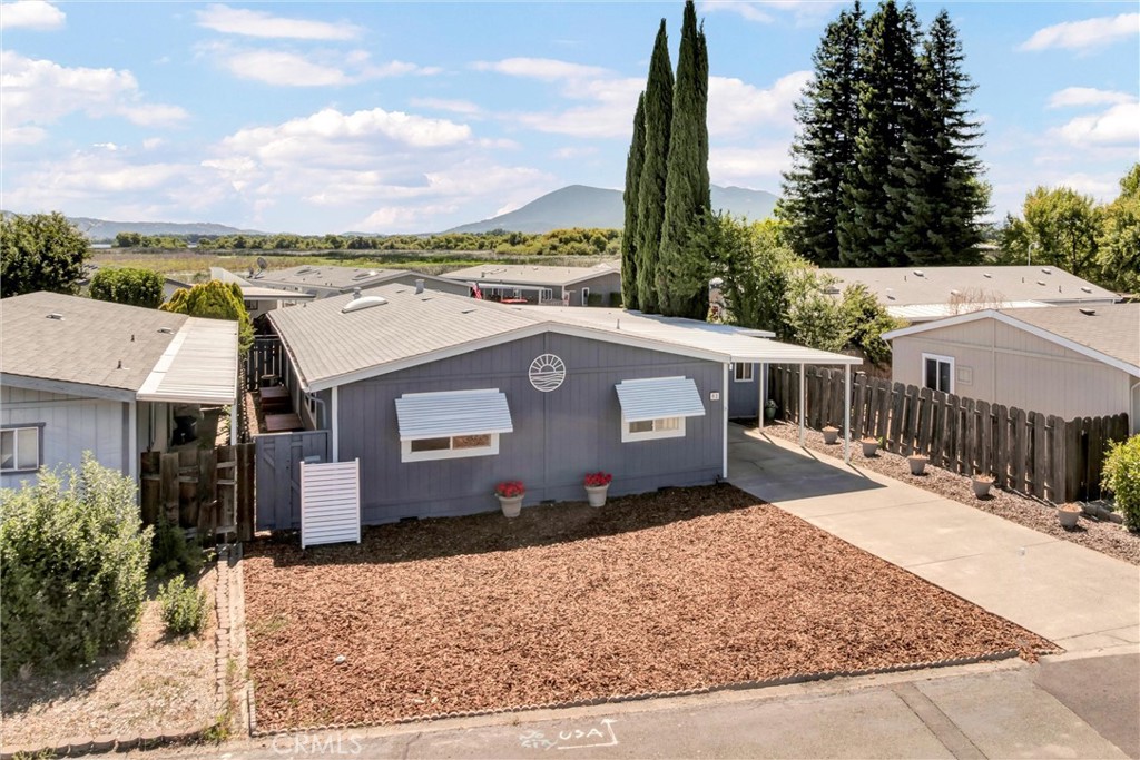 Enjoy a home away from home or settle in full-time in this spacious 4-bed/2-bath home nestled in the Pier 1900 subdivision! Pier 1900 is a versatile and welcoming community with no age restrictions. This well-maintained property features a BRAND-NEW ROOF offering peace of mind for years to come. With low-maintenance front & back yards, you'll find easy upkeep while you're away or the perfect canvas to add your personal touches and bring out its charm. There is ample parking under the attached carport, including space for your vehicle(s) and multiple boats with the added convenience of a pull-through breezeway with street to street parking. Step inside to a freshly painted interior featuring high vaulted ceilings in the living room, kitchen, and primary bedroom. A kitchen skylight brings natural light into the heart of the home, where you'll find generous counter and cabinet space for your cooking needs. Carpeted bedrooms and living areas add comfort, while tiled floors in the kitchen, laundry room, and bathrooms offer easy maintenance. The primary suite features views of Mt. Konocti from the Eastern window and includes a walk-in closet to accommodate your wardrobe with ease. Separate large family room offers flexibility for additional living space. The home's split floor plan provides privacy and balance, and the property is fully electric. Land is owned beneath, so you don't have to worry about space rent increases! HOA includes option for boat and trailer storage for homeowners. Unit #52 is located near the Bocce Ball court and across the street from transportation and shopping. Schedule your tour today and enjoy the best of Lake County living!