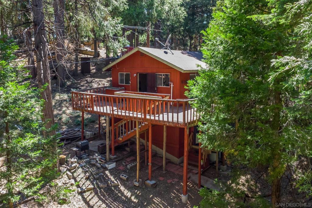 Escape to your own private mountain hideaway! This unique property offers a blend of charm, functionality, and plenty of extra space to make your own. A brand new chain-link fence secures part of the lot, and the oversized wraparound deck invites you to soak in the peaceful surroundings from multiple vantage points. Inside the main home, an open floor plan centers around a cozy fireplace, while large windows flood the space with natural light. The primary bedroom includes an attached half bath, and the full bath is conveniently located near the main living areas. Downstairs is where the potential really shines—discover a 19x7 enclosed laundry porch plus multiple bonus spaces below the main level: a 16x15 finished room perfect for a home theater, gym, or game room, plus two additional areas (12x9 and 9x7) ready for your creative vision. Power is already connected throughout, and the largest bonus room even includes a sink. Whether you’re looking for a weekend escape, full-time living, or a rental opportunity, this mountain retreat is packed with possibilities. Come experience it for yourself!