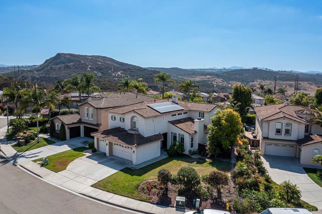 Welcome to this stunning 5-bedroom, 3-bath residence nestled in the highly sought-after exclusive Calavera Hills community of Carlsbad. Perfectly situated on a private, elevated lot on a quiet cul-de-sac, this nearly 3,000 sq. ft. home offers a rare blend of comfort, elegance, and functionality. The front yard provides plenty of insulation from your neighbors and offers generous space large enough for a deck. Step inside to discover a spacious floor plan with an abundance of natural light pouring in all angles from the array of oversized windows throughout. There is a desirable downstairs bedroom and adjoining full bath, ideal for guests or multi-generational living. The expansive chef’s kitchen boasts a large center island, granite counters, five-top burner, walk-in pantry, stainless steel refrigerator, and it seamlessly flows into the family room—perfect for everyday living and entertaining. The spacious formal dining and living rooms add timeless sophistication for special gatherings. Upstairs, retreat to the grand primary suite with breathtaking mountain views, a private balcony, and a spa-inspired bath featuring dual vanities, soaking tub, and two large walk-in closets. Three additional roomy upstairs bedrooms and a full bathroom provide ample space for family, home office, or hobbies. Enjoy year-round outdoor living in the entertainer’s backyard. The expansive patio flows seamlessly from the home, providing multiple zones for dining, lounging, and social gatherings. There is plenty of room for an outdoor kitchen, firepit, or shaded seating areas, making it ideal for hosting everything from casual barbecues to elegant evening parties. Whether you’re relaxing in the sun or entertaining guests, the layout and generous space make this backyard an entertainer’s dream! With leased solar panels, dual A/C, and an oversized 3-car garage, this home is as practical as it is beautiful! Located within walking distance to top-rated schools, the Calavera Hills trailhead, and the unrivaled 260-acre Calavera Nature Preserve with endless hiking and biking trails, this home also offers quick access to shopping, dining, pristine beaches, and major freeways. Experience Carlsbad living at its finest in this exceptional home that truly has it all.
