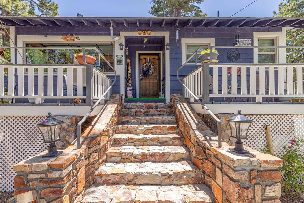 This vintage Big Bear Lake Cabin has all the classic touches, including native rock entry steps, wood paneled walls, Maltby-style native rock fireplace, open beam ceilings, and single and lap siding. The 120 degree lakeviews from the large front deck and massive 10’ picture window highlights the lake access, which is only 100 feet away! Cozy up to the wood burning stove in living room or the pellet stove in the kitchen on winter evenings, and keep the dogs safe in the 40’ enclosure when they’re not cuddled up with you. The gently sloped backyard is great for snowplay, and the large lot could accommodate adding on. Modern upgrades include dual pane windows, updated plumbing and wiring, updated washer & dryer. Sellers recently installed a new sewer system, roof, paint, natural gas heater, water heater, concrete driveway, garbage disposal, shower-in-tub enclosures, toilets, vanities, kitchen sink and faucet, flooring in dining, living, bedrooms and two baths, new stairway caps and handrails, and steel security screen doors. This property could make a great mountain getaway, investment, or residence. Come up and get away from it all a mile closer to heaven!
