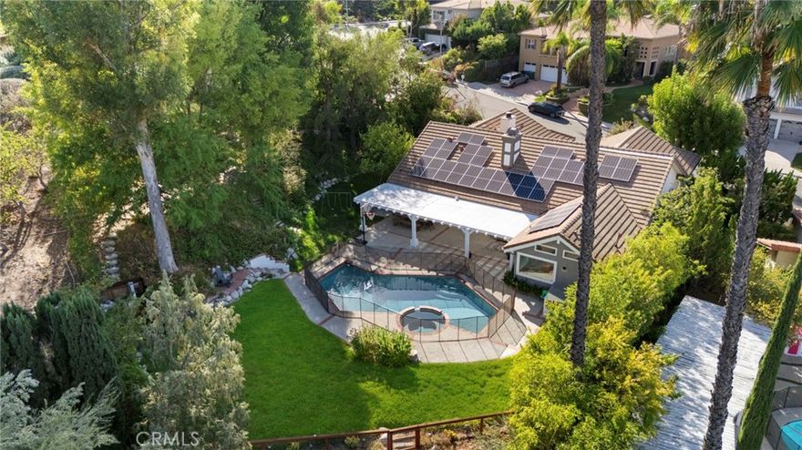 This beautifully updated single-story home blends timeless character with modern upgrades and thoughtful details throughout. Privately set on a serene lot with far-reaching views, mature trees, and a lush backyard perfect for entertaining, this residence offers effortless indoor-outdoor living just moments from Lazy J Ranch Park. Step inside to discover light-filled, open yet defined living spaces with vaulted ceilings, exposed beams, and smooth skim-coated walls. The home has been extensively improved with new double-pane windows, all new doors, recessed lighting, and White Oak engineered floors. The chef’s kitchen, newly renovated, features a Dacor refrigerator and range, Fisher & Paykel drawer dishwasher, sleek cabinetry, and elegant finishes. The trendy bathrooms, showcase floating vanities, arched mirrors, and tasteful tile flooring that combine modern style with timeless appeal. The primary suite impresses with a beamed, vaulted ceiling, spacious walk-in closet and a large ensuite bath filled with natural light and refined finishes. Outside, the backyard is a true retreat—featuring a heated pool, freshly repainted pergola, drip irrigation, enhanced outdoor lighting, and a raised herb garden. The expansive lawn and multiple lounge areas create an ideal setting for gatherings or quiet relaxation under the trees. Bonus Alert: Fully paid-off solar system, EV charger, and a whole house water filtration system.