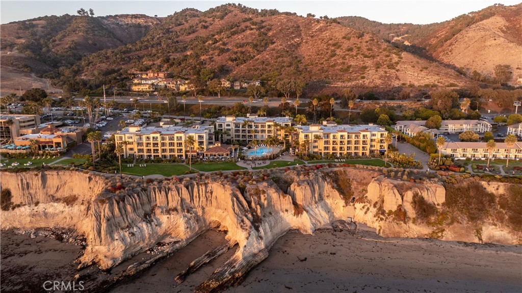 Experience the essence of refined coastal living in this elegant luxury condominium located within the renowned Dolphin Bay Resort. Perched atop the scenic bluffs of California's Central Coast, this residence offers a rare opportunity to own a resort-style home with access to world-class amenities and services. This single-level suite welcomes you with custom travertine stone flooring that flows throughout the space. The gourmet kitchen is outfitted with granite countertops, stainless steel appliances and custom wrap-around cabinetry, creating both beauty and function. The kitchen opens to an open dining area, making the space ideal for relaxed entertaining. Through large sliding doors, you'll find a fully glassed-in deck, perfect for enjoying a glass or wine and taking in incredible Shell Beach sunsets. The spacious living room features a updated fireplace, recessed ceilings, and a built-in entertainment alcove, offering a warm and stylish space to unwind. The generously sized bedroom provides a peaceful sanctuary, with easy access to the beautiful bathroom with ample lighting. Upgrades include recently installed canned lighting in the kitchen, electrical upgrades though out the suite, newly installed electric fireplace, ceiling fans, and more. As an owner at Dolphin Bay, you’ll enjoy the benefits of four-diamond resort services: room service, concierge, world class spa services and house keeping services(fees apply). Amenities include a heated pool and hot tub with poolside service, fitness center, oceanfront lawn, BBQ area, fire pit, and beautifully manicured grounds. Dining at the award-winning Lido Restaurant and relaxing at the on-site spa complete the luxurious experience. HOA dues cover cable, water, gas, trash, maintenance, internet, cable TV and full use of all common areas and amenities, making ownership seamless and hassle-free. This unique opportunity offers the option to participate in the resort's rental pool program, which gives you the flexibility to generate income without the headache of managing the property. Whether you're seeking a personal sanctuary or a smart investment opportunity, this extraordinary suite offers the ultimate in Central Coast lifestyle and luxury.