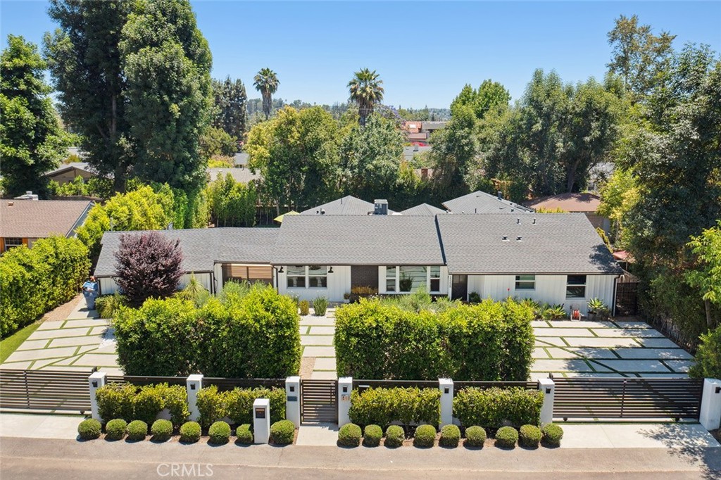 Stunning completely remodeled Walnut Acres single story estate! Privately situated behind two automatic security gates with separate pedestrian access that open to a wide sweeping circular driveway with 2-car garage and impeccable landscaping with drought tolerant plants and olive trees. Step inside to find a completely open floor plan filled with natural light, custom detailing, and designer finishes. The gorgeous kitchen boasts center island with separate prep sink, quartz counters, custom soft close cabinetry, stainless appliances including Thermador range with double ovens, 6-burner cooktop with griddle and custom vent hood, and pantry space with pull out drawers. The kitchen opens directly to all living spaces including an oversized family room with high ceiling and glass slider that opens to the yard, sitting room with custom wood accent wall, formal dining room space with large picture windows, and built-in bar with wine fridge, open shelving, and built-in storage. There are four bedrooms, each featuring their own private bathrooms. The luxurious primary suite features private entry foyer, large bedroom with vaulted ceiling, mantled fireplace flanked by built-in storage, private glass slider that opens to the yard, luxurious walk-in closet with center island, and private spa-like bathroom with integrated dual sink vanity, walk-in shower with skylight, built-in linen storage, and separate toilet room. The three secondary bedrooms each feature large closets with built-ins and each has their own uniquely designed en-suite bathrooms with walk-in showers. One of the secondary bedrooms is located on its own wing ideal for guests or office. There is also a guest powder bathroom and mud room/laundry with custom built-ins and exterior access. The entertainer’s super private backyard features swimming pool with elevated spa and spillover waterfall, large synthetic lawn, massive covered patio with built-in heater and ceiling fan, and wraparound mature hedging for ultimate privacy. Adjacent to dining/shopping at the Westfield Mall/Village, Calabasas Commons, Warner Center & zoned for award-winning El Camino & Hale charter schools.