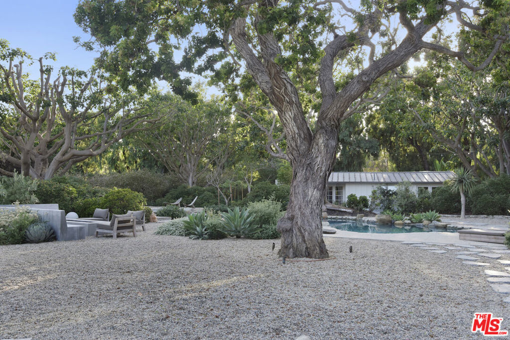 This sensational Point Dume house is set on more than an acre of gated and landscaped privacy. Complete with beach rights, it is a home created for comfortable indoor/outdoor living and sophisticated entertaining. The home is detailed with high wood-beamed ceilings, Fleetwood glass doors and cement floors. In addition to a beautiful living room, the home has a media room, family room with fireplace, a dining area, and a chef's kitchen equipped with a Viking stove and oversized Sub Zero refrigerator and freezer. Large 12-foot sliding doors open the house to the front and back yards. There are three bedrooms and four bathrooms, plus an office/bonus room, with a fireplace, that could be a fourth bedroom. The owner's suite has a fireplace, a wall of glass doors opening to the back patio, and a luxurious garden-view bath with a huge shower, tub, and double sinks. The exquisite grounds are tranquil and harmonious, with a pool and spa, dining area, fire pit, double barbecue island, multiple recreation and seating areas among beautiful trees and plantings, and a detached one bedroom guest house. The home is also equipped with modern updates such as Sonos speakers, Generac auxiliary power, NEST heating and cooling, and security entry. This exceptional property is just a short distance to Riviera 2 private beach access. Available July 1st, 2025.