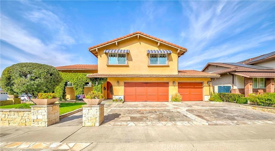 Spectacular luxury living in the prestigious city of Anaheim Hills! Charming corner-lot pool home in a prime location with an entertainer’s dream backyard. Welcome to your very own Tuscan-inspired sanctuary, a stunning outdoor paradise featuring a sparkling saltwater pool & spa, custom hardscape, elevated lounging and dining areas, and a peaceful koi pond. Enjoy unforgettable gatherings under the string lights, whether dining on the terrace or relaxing by the cozy fire pit as the stars come out. This entertainer’s haven also offers a fully equipped outdoor kitchen with built-in BBQ, stove, dishwasher, and refrigerator, plus a beautiful covered California room with dual ceiling fans, fireplace, and stamped stone pathways throughout. Here, every space is designed for relaxation, connection, and everyday luxury. Inside, this spacious home features 4 bedrooms + 3.5 baths and approx. 3,042 sq ft of living space on an approx. 8,165 sq ft lot. The main floor includes a large living room with fireplace, wet bar, and sliding doors for seamless indoor/outdoor flow, along with a convenient bedroom and full bath, plus a guest bathroom. Just a few steps up is the impressive kitchen, offering granite countertops, built-in 5-burner range & hood, dishwasher, abundant cabinetry, and a generous center island, open to the dining and family room for effortless entertaining. A few more steps up leads to the luxurious primary suite featuring an oversized walk-in closet with custom built-ins, projector screen with surround-sound hookup, and a beautifully remodeled ensuite with dual sinks, vanity, and large walk-in shower. Two additional bedrooms with ample closet space share an updated hallway bath with dual sinks and shower in tub. Additional upgrades include PAID-OFF SOLAR, newer AC & furnace, newer tankless water heater, Venetian plaster walls, recessed lighting, and wood/travertine flooring throughout, plus so much more! Direct-access 3-car garage with laundry hookups (ask agent for details). This home is filled with character, charm, and true pride of ownership. Centrally located near top-rated schools, shopping, dining, parks, hiking trails, entertainment & easy 91 freeway access, all in a wonderful neighborhood with many long-time residents. Don’t miss this rare, once in a lifetime opportunity!