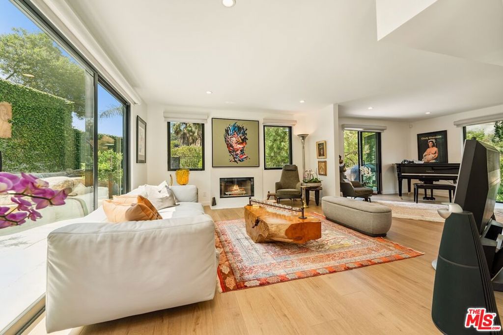 Extensively remodeled, this transitional Beverly Hills estate seamlessly blends timeless character with sophisticated modern updates. Spanning approximately 3,095 square feet, the home showcases newly installed wide-plank white oak floors, custom cabinetry, and curated designer finishes throughout.Expansive living spaces are filled with natural light, with floor-to-ceiling sliding doors and windows that frame peaceful canyon views and create a seamless indoor-outdoor connectionideal for both relaxed living and entertaining.The gourmet kitchen is outfitted with Bosch appliances, including a SMEG cooktop and a built-in wine cooler, offering both functionality and elevated style.Three spacious bedrooms include a beautifully updated primary suite with a spa-inspired bathroom featuring a freestanding pedestal tub, dual vanities, and a generous walk-in closet. An additional en-suite guest bedroom provides comfort and privacy.Set behind gates on over an acre, the ultra-private backyard offers a resort-like atmosphere, complete with mature landscaping, meandering garden paths, and a custom pool with spa and waterfall. Multiple outdoor dining and lounge areas make this canyon sanctuary a rare and refined offering in Beverly Hills.