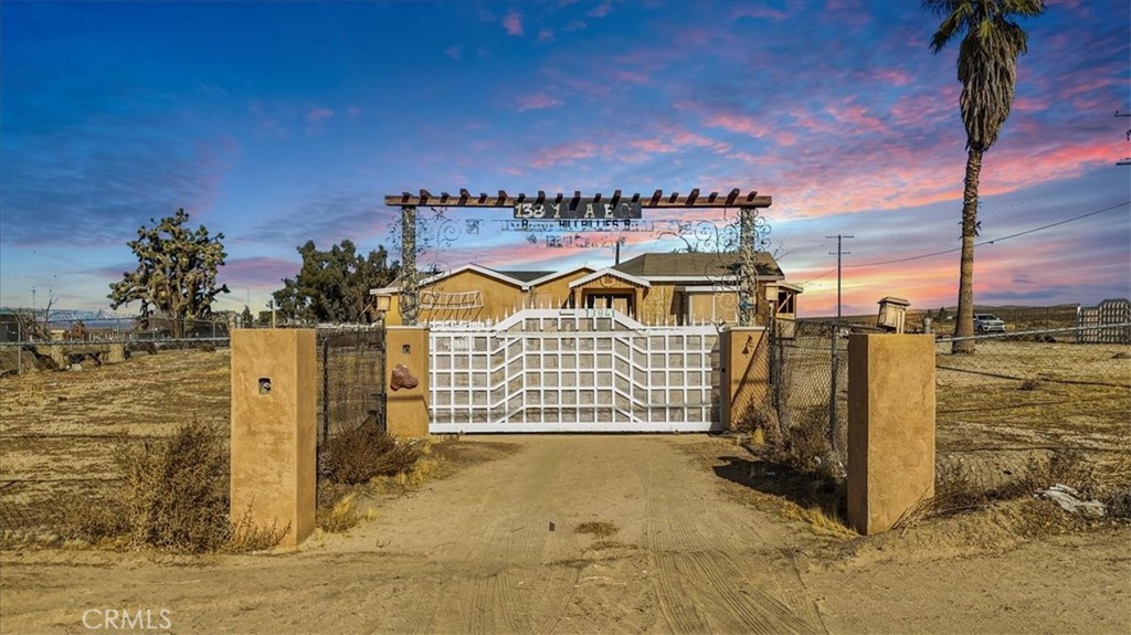 Custom Home Project. This 3-bedroom, 2-bathroom home sits on 1.33 acres of fully fenced and gated land on a corner lot with both dirt road and paved street access off 140th St E. Per seller, construction began in 2015, giving buyers a more modern starting point compared to many homes in the area. The property is currently an unfinished construction, allowing the next owner to complete and customize the home to their own style and needs. Previous plans for completion and additions may have expired, providing a fresh opportunity for buyers to design their vision. The lot also features a small storage shed, wide open space for expansion, and scenic desert and mountain views. Enjoy rural living with a neighborhood feel while being only about 35 minutes from Palmdale.
