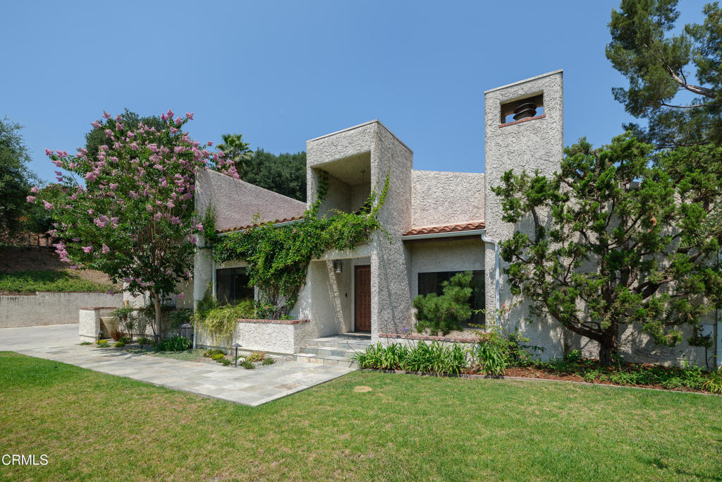 Located at the end of a long, gated driveway on a quiet cul-de-sac in South Pasadena's sought-after Altos de Monterey neighborhood, this spacious single-story home offers flexibility, privacy, and broad views of the San Gabriel Mountains and city lights. Set on over an acre of verdant grounds, it combines generous interior living with a serene outdoor setting.The main house features five bedrooms and four bathrooms, while a free-standing guest quarters adds a sixth bedroom, full bath, and living room--ideal for friends, extended family, or a dedicated workspace.Inside, high ceilings and large windows bring in abundant natural light. The formal living and dining rooms each feature a fireplace, picture windows, and sliding glass doors that open to a covered loggia. The kitchen is outfitted with granite countertops, stainless steel appliances, ample storage and a built-in breakfast table. Immediately adjacent is the family room, which includes a wet bar and custom cabinetry--perfect for casual gatherings and formal entertaining.The expansive primary suite has direct access to the yard, a walk-in closet, and a spa-style bath with soaking tub and separate shower.Outdoors, a pool and deck are nestled among mature trees and natural landscaping. Multiple areas for entertaining or quiet retreat include an Asian-themed courtyard garden with hand-pruned specimen trees. Additional amenities include an indoor laundry room and a two-car garage with direct entry.Just minutes from the 5, 10, and 110 freeways and Monterey Hills Elementary, this home offers a flexible layout, peaceful setting, and a prime South Pasadena location.