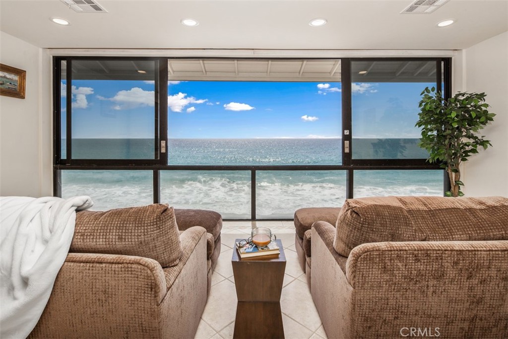 Unmatched Oceanfront Living – This tri-level coastal retreat offers panoramic ocean views from every level. First-floor room (currently an office) can be converted into a bedroom upon request, complete with an in-shower bathroom. Floor-to-ceiling windows on the main floor slide open to the patio and invite endless ocean breezes and coastal views. Tile floors. Enjoy the breathtaking beach horizon from the second-floor living room windows as well. Open-concept second level includes kitchen, dining, and living areas with a wet bar for entertaining, also tile floors. The third-floor master suite offers sweeping views and soothing sounds of the waves while dreaming. Two bedrooms and two separate baths on the top level offer privacy and carpeted floors, with a full bathroom for the guest bedroom and an en-suite, stand-up shower in the master bedroom. Two-carport spaces and in-unit w/d included. Gated community features two pools, tennis court, and direct beach access. Fully furnished or may be available unfurnished. Live closer to the ocean than you ever imagined.