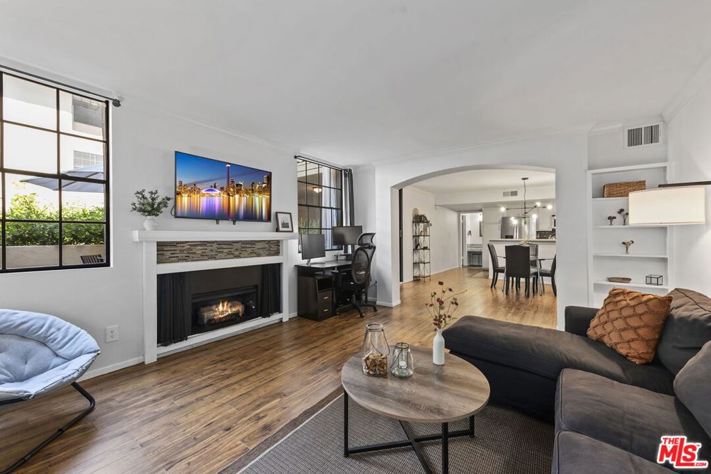 This stylish 1 bed, 1 bath condo combines modern upgrades, timeless design, and resort-style amenities in a prime West Hollywood location just steps from Melrose Place. Bathed in natural light, this spacious condo offers over 800 sq. ft. of living space, plus a private 300 sq. ft. patio for outdoor enjoyment. One of only two units in the building with a private courtyard featuring both covered and open-air spaces that rival the feel of a single-family backyard. Interior features include wood flooring, a separate dining and living area with fireplace, stainless steel appliances, and a newly remodeled shower. The spacious bedroom includes a walk-in closet with built-ins and direct access to the private courtyard. Additional highlights include central A/C and heat, an upgraded building access system with touchscreen and phone notifications, and one deeded gated garage parking space. Community amenities elevate the lifestyle: a rooftop deck with panoramic city and hill views, BBQ area, spa, sauna, fitness center, billiards room, secure package lockers, EV/Tesla charging, guest parking, and laundry on every floor. Low HOA dues cover water, trash, gas, and earthquake insurance. Perfectly positioned near Melrose boutiques, Santa Monica Boulevard cafes, Cedars-Sinai, and Beverly Hills, this home offers the best of LA convenience, and a quiet retreat in the heart of it all.