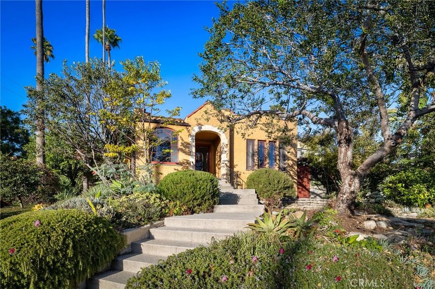 Welcome to “The Burrow,” a soulful bohemian escape that feels worlds away, yet sits just moments from the Silver Lake Reservoir, vibrant cafés, and eclectic shops. Originally built in 1922, this Spanish sanctuary has been lovingly reimagined with designer finishes and an inspired sense of style. Once home to the longtime curator of Frank Lloyd Wright’s Hollyhock House and Simon Rodia’s Watts Towers, the residence carries a rich creative legacy woven into every detail. Inside, layers of character and craftsmanship unfold. The formal living room opens seamlessly into an elegant dining area and an expansive family room anchored by its original CalCo tile mantel, creating an entertainer’s dream of openness and warmth. The bespoke kitchen blends form and function in perfect harmony, featuring Viking, Bosch, and Monogram appliances set against a backdrop of refined design. Every corner reveals eclectic details and soulful touches, updated throughout with a brilliant design sensibility that feels at once contemporary and timeless. Outside, the magic deepens. A lush Joseph Marek–designed garden wraps the home in tranquility, with mature plantings, hidden nooks, a potting shed, and a spacious loggia that blurs the lines between indoor and outdoor living. Here, everyday moments feel like a retreat, whether entertaining under the stars or quietly escaping the rhythm of the city. With two bedrooms, a beautifully refreshed bath, and abundant architectural character, this is more than a home; it’s a one-of-a-kind creative refuge in the heart of Silver Lake awaiting its new chapter.