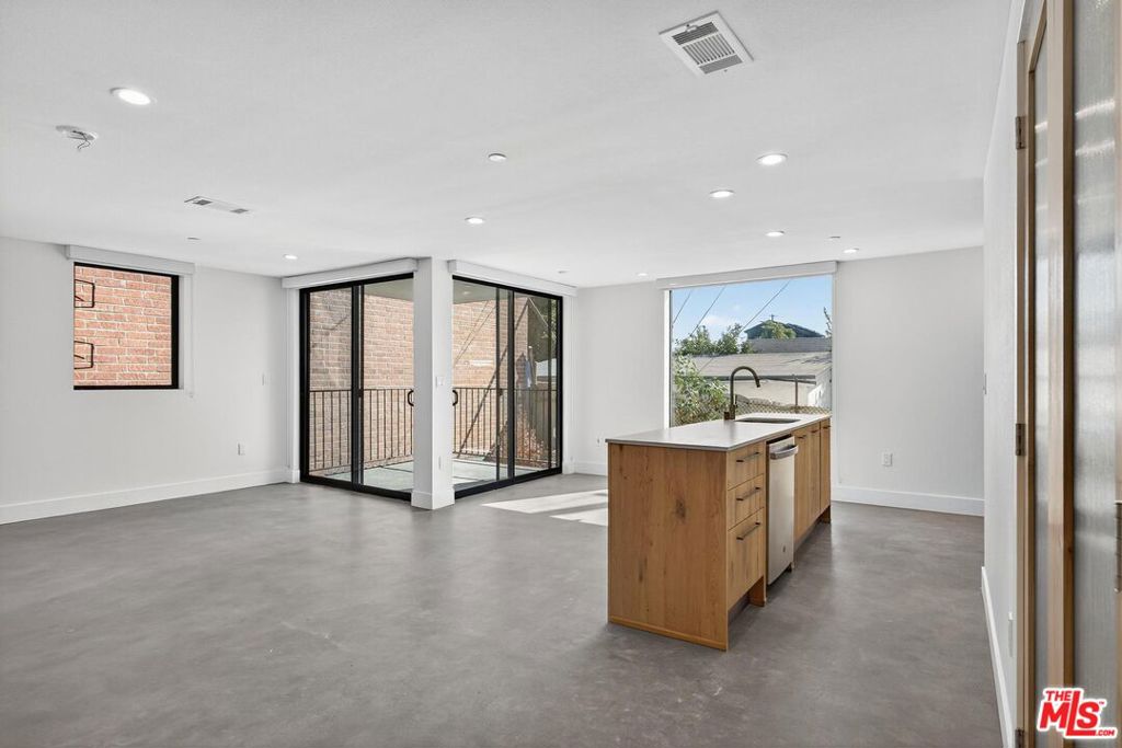 Here in what's known as Frogtown, a slice of Los Angeles alongside the river, is a new building. These are live/work lofts, designed for a life built to be both efficient and inspired. The space is defined by clean lines and unblemished surfaces, with floor-to-ceiling windows that not only bring the world in but also frame it beautifully. Inside, you'll find a modern kitchen and two and a half bathrooms. The layout includes a bedroom loft and a main bedroom that opens directly onto a private patio. For convenience, a washer/dryer and dishwasher are tucked away in the kitchen area. The building provides peace of mind with gated parking and electronic entry. The private patio offers a quiet escape. From there, you can observe the true character of the city, the warehouses and power lines, as well as the river that gives the neighborhood its identity. Located in the heart of Frogtown, you're just moments away from the best of the Eastside.
