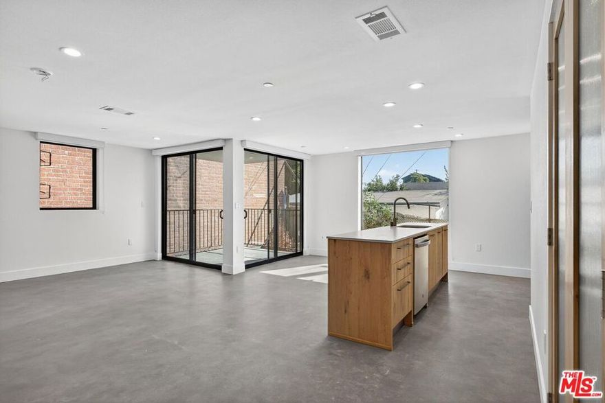 Here in what's known as Frogtown, a slice of Los Angeles alongside the river, is a new building. These are live/work lofts, designed for a life built to be both efficient and inspired. The space is defined by clean lines and unblemished surfaces, with floor-to-ceiling windows that not only bring the world in but also frame it beautifully. Inside, you'll find a modern kitchen and two and a half bathrooms. The layout includes a bedroom loft and a main bedroom that opens directly onto a private patio. For convenience, a washer/dryer and dishwasher are tucked away in the kitchen area. The building provides peace of mind with gated parking and electronic entry. The private patio offers a quiet escape. From there, you can observe the true character of the city, the warehouses and power lines, as well as the river that gives the neighborhood its identity. Located in the heart of Frogtown, you're just moments away from the best of the Eastside.