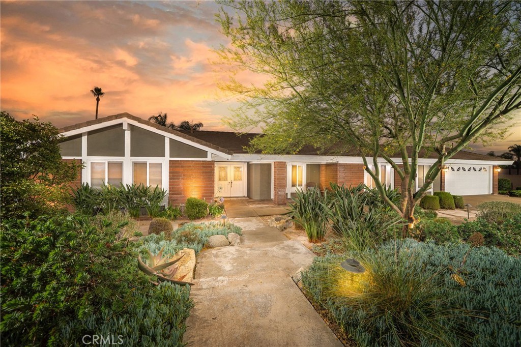 Located in North Claremont on a spacious corner lot, this beautifully updated property combines timeless design with modern comfort. The front yard features colorful, drought-conscious landscaping on a drip irrigation system, adding vibrant curb appeal and thoughtful sustainability. Inside, rich flooring and expansive windows create a warm, light-filled atmosphere throughout the home. The living room sits just off the entry, while the expansive family room is a standout, anchored by a custom tile fireplace that adds character and warmth. Adjacent to this space, the dining area enjoys serene backyard views and flows into the open-concept kitchen. The kitchen includes ample cabinetry, granite countertops, a tasteful tile backsplash, and a builtin gas cooktop. A breakfast counter adds additional versatility, making the space ideal for everyday living or entertaining. The home offers four generously sized bedrooms and two updated bathrooms, both featuring dual sinks. The primary suite is particularly spacious, complete with an en suite bathroom that includes dual vanities, a large walk-in shower, and a soaking tub designed for relaxation. The backyard offers a versatile space that's ideal for both relaxing and entertaining. A large covered patio creates a shaded retreat perfect for outdoor dining or relaxing, while the open layout of the yard allows for easy customization to fit your lifestyle. Whether you envision adding a garden, lounge area, or outdoor kitchen, there's ample room to bring your ideas to life. An additional spacious grassy area is a great place for play. Mature trees and privacy fencing provide a quiet, comfortable atmosphere, making it a natural extension of the home.