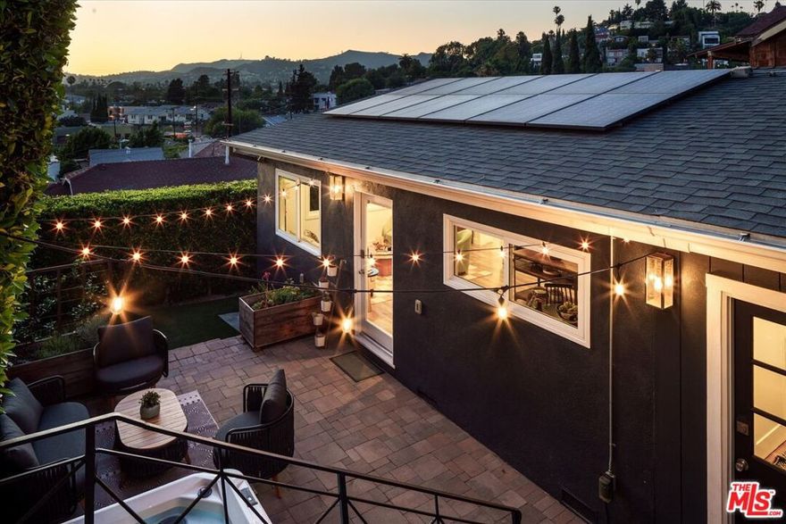 Enter beyond the front gate into this private Silver Lake oasis with yard, panoramic city views, and spa in the heart of Silver Lake! This sunny, quiet, and upgraded California Bungalow offers a bright open-concept kitchen, living and dining area, all orienting toward amazing views of the iconic hills, Hollywood Sign, and the Griffith Observatory. Off the kitchen, a flexible mudroom or home office nook offers access to the yard. The spacious primary bedroom features a walk-in closet; adjacent hall bathroom with dual sink vanity and second bedroom with lovely city views and a private balcony complete the main home's floor plan. Set below terraced gardens with mature fruit trees is a charming, bricked patio area complete with spa and lounging area - perfect for year-round entertaining and enjoyment. As day turns to night, take in expansive sunset views and watch the city and hillsides twinkle into the twilight. A zero-maintenance turf yard leads to the newly finished basement office/studio with a half bath, plus laundry area and abundant storage. Considered updates throughout the home include all new induction stove; electric washer, dryer, and hot water heater; foundation retrofitting; and drainage improvements. Owned solar panels consistently offset the cost of the home's electric bill in the summer months. Just steps from your door, grab your morning coffee at Intelligentsia, browse the weekly Farmers Market, and dine at Pine & Crane, Bacari, or any of the innumerable cafes and restaurants in the Sunset Junction. Daily essentials at Gelson's, Trader Joe's, and Erewhon and weekend strolls around the Reservoir are all within easy reach. Experience comfort, convenience, and unparalleled Eastside charm in this exceptional home.