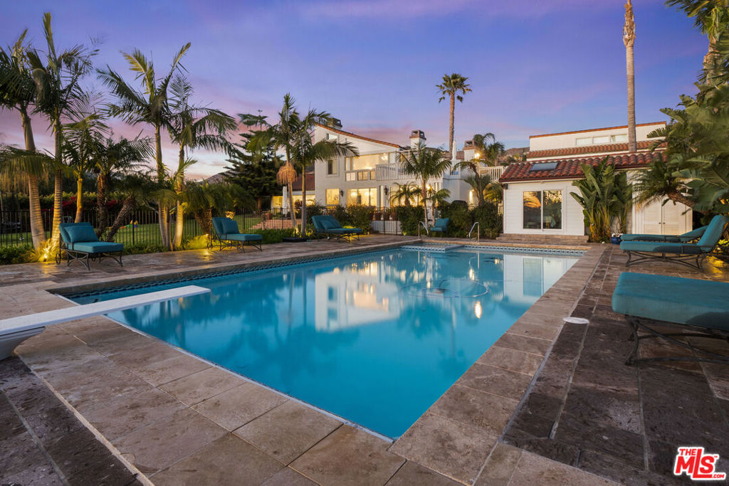This Mediterranean contemporary Malibu Park estate with an ocean view on approximately 2.3 acres offers luxurious living. It provides privacy and security, with ample space for guests and entertainment. Whether enjoying time with family or hosting lavish events, it is the ideal location for any occasion. There are 6 bedrooms and 6.5 bathrooms. The primary suite includes two private baths, two walk-in closets, and a sitting room. Enjoy breathtaking sunsets, and tranquil nights from the upper private deck. The home is finished with the finest materials and has an abundance of natural light. Large windows overlook the private estate and magnificent ocean. The formal living room centers on a cozy fireplace, and the kitchen is newly remodeled with superior stainless steel appliances and ample counter space. The home opens to a private terrace with a large, sparkling pool and spa. The property rolls gently down to Hawaiian-landscaped full palms and a manicured garden. Beyond the terrace is a wide-open space suited for many activities, gardens, and even potential horses. The entire property is gated for added security. The new driveway leads to a 3-car garage and 6 additional parking spaces. This luxurious home is moments away from Zuma Beach, groceries, shopping, restaurants, and Malibu High School.