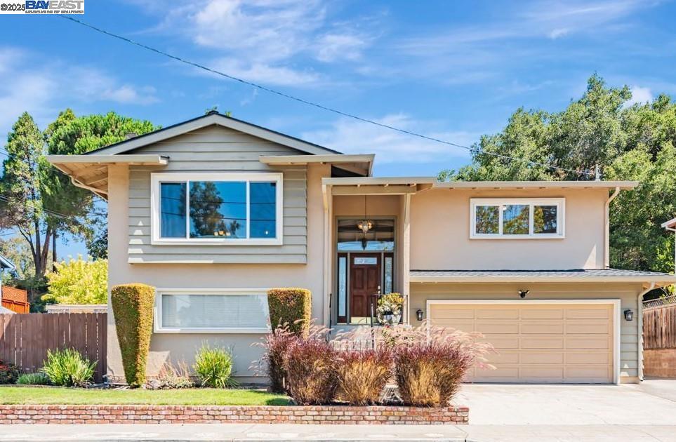 Located on a generous lot at the top of the hill, this beautifully maintained home offers charm, space, and scenic surroundings. With abundant natural light streaming through large windows, the interior feels bright & welcoming throughout. The home features a well-designed two-level layout. Upstairs, you'll find 3 bdrms, 2 bthrms, a kitchen, & an open, airy livingroom centered around a large picture window w/partial views. Hardwood floors, recessed lighting, & a cozy fireplace add timeless appeal. The spacious primary bedroom overlooks lush landscaping & a terraced hillside, providing a peaceful retreat at the end of the day. The lower level includes an oversized family room, an additional bdrm & bthrm, ideal for guests, home office, or multi-generational living. Both the familyroom & downstairs bedroom offer sliding glass doors that open to the backyard, creating a seamless indoor-outdoor flow. Outside enjoy an extensive covered deck, perfect for entertaining or quiet evenings surrounded by nature. The backyard is a private space featuring a lawn, covered patio, charming gazebo, retaining walls w/wrought iron accents & tranquil terraced hillside views. NO REAR NEIGHBORS! RV side access. New Haven Schools a BIG plus. A rare opportunity!