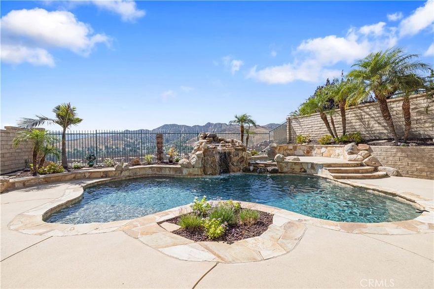 Welcome to your own private resort! This stunning home features an epic SALTWATER POOL with waterfalls, a hidden grotto, relaxing spa, built-in BBQ, and BREATHTAKING VIEWS—creating the ultimate staycation retreat right in your backyard. Inside, you'll find 4 bedrooms (one downstairs), 3 baths, PLUS SPACIOUS LOFT across 2,358 sq. ft. of beautifully maintained living space. The home welcomes you with exceptional curb appeal, and once inside, you’ll enjoy tile flooring throughout, a bright living room, and a spacious family room with a cozy fireplace and custom media niche. The remodeled kitchen offers granite countertops, stainless steel appliances, and a center island overlooking the resort-like backyard—perfect for entertaining. A downstairs office (or optional 4th bedroom) and ¾ bath complete the first level. Upstairs, the large loft opens to the living area below. The primary suite offers panoramic views of the Santa Clarita Valley, a spa-like bathroom with dual sinks, tile floors, and a generous walk-in closet. Two additional bedrooms and a hallway bath with dual sinks provide comfort and functionality for the whole family. Step outside to an entertainer’s paradise—a pebble-tec saltwater pool & spa with waterfalls, grotto, and BBQ island with refrigerator, plus a covered patio, side-yard dog run, shed, and custom-built playhouse. Additional features include a three-car tandem garage with epoxy floors and access to community amenities such as scenic paseos, Northlake Elementary, pool, spa, tot lot, and sports court. Conveniently close to Castaic Lake Recreation Center, the Aquatic Center, and the 5 Freeway for easy commuting. This home truly has it all—luxury, comfort, and the ultimate backyard escape.