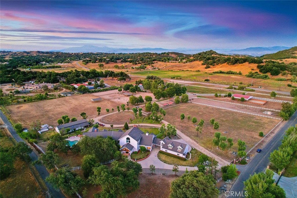 ATTENTION: DEAL-MAKERS, INVESTORS, EQUESTRIANS – DEAL OF A LIFETIME! BRING ALL OFFERS! Priced to sell, well below the current market and a fraction of the cost of building. Property sold As-Is, Buyer to do all investigations. This dramatic estate with exposed wood beams is appointed with luxury details and all the comforts of a stately main house, including separate apartment with kitchenette, stunning pool with spa and fireplace, outdoor kitchen, wide-open pastures, prolific private water well, mature landscaping, ancient oaks, privacy gate, and sprawling, fully fenced grounds with direct access to miles of community riding trails. Sprawling 7670 total (5471 main house + apts) square-foot estate complex with open concept floorplan offers luxurious living. This home boasts gorgeous exposed-beam ceilings, a massive Great Room with soaring 40-foot ceiling, a remodeled chefs’ dream kitchen with custom cabinetry and Wolf appliances, all main-house bedrooms on lower level, expansive loft with balcony, custom walnut and marble flooring…On the highly desired Equestrian Row in Tenaja on the Santa Rosa Plateau, this massive estate on 8 flat acres awaits! Flat, usable land allows you to create a Dream Ranch or epic Agricultural Masterpiece. Truly stunning living in one of the most beautiful areas of the Santa Rosa Plateau! Opportunities with this many amenities do not come along often, and certainly not at this low price! *****SANTA ROSA PLATEAU: 5-acre minimum parcels (10-acre minimum in SR West), just minutes to schools, restaurants, hospitals, grocery stores, 15 Fwy & Temecula Wine Country. Enjoy this peaceful ranch community w/no commercial businesses, robust social activities, miles of private community trails & 1000s of acres of Ecological Reserve…All less than 1.5 hours from LA, SD, OC, Palm Springs & Big Bear. Discover the country, yet convenient, lifestyle of La Cresta, Tenaja & the Communities of the Santa Rosa Plateau!