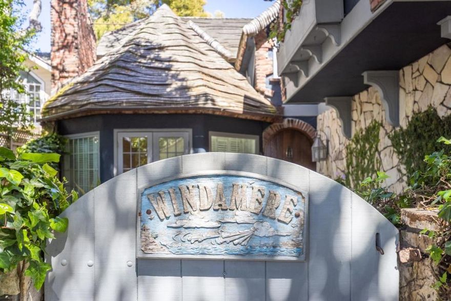 Designed and built by Steven Munkdale in 1982, whose firm was renowned for their design of the Cannery Row bike trail and Carmel Beach walkway, Windamere was known as one of the best-designed Carmel-by-the-Sea homes at the time. Photographed by thousands, its storybook wavy roof is eye-catching, and its signature blue color exudes coastal charm. The spacious 2,191 sq ft home is anchored by a large octagonal living room with hickory pecan hardwood flooring throughout the home and a soaring stone-clad fireplace. The well-appointed kitchen features gas appliances, stone flooring, marble counters, and cherry cabinets. An elegantly designed iron staircase connects the main floor to the second floor, leading to two guest bedrooms with interior patio views and a guest bathroom with a separate tub and shower. The primary suite w/office is light and airy, offering a private patio, glimpses of the ocean towards Stillwater Cove, and a master bathroom to admire with its stone tub, shower & marble counters. French doors open to a private backyard blooming with vibrant gardens, multiple patios, and a stone water feature, providing year-round delight. No spared expense on design, materials and craftsmanship went into creating Windamere. A legacy property to be enjoyed by generations.