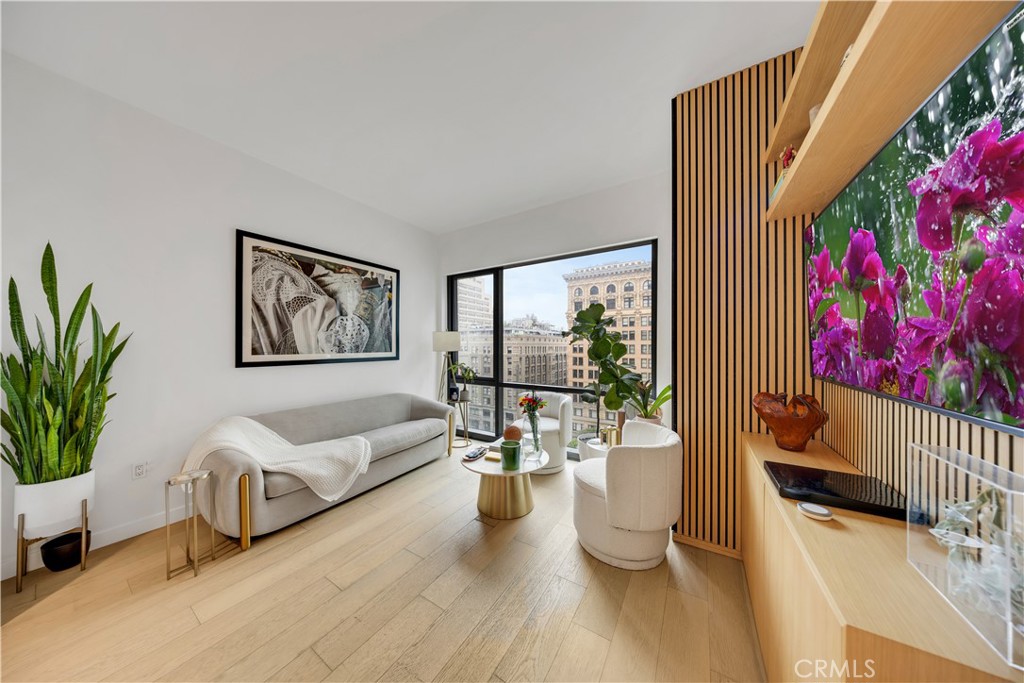 Welcome to Perla on Broadway, Downtown LA’s premier luxury high-rise where lifestyle and sophistication meet. This stunning 1-bedroom, 1-bath residence offers 673 square feet of thoughtfully designed living space with breathtaking views of the Downtown skyline. Elegant custom upgrades include wood slat detailing with integrated shelving and cabinetry, a tailored closet organization system, designer drapery in the bedroom, and a dedicated home office with built-in shelving and desk, all complemented by wide-plank hardwood floors in a refined natural finish, lending warmth and timeless elegance to the contemporary design, and floor-to-ceiling windows that flood the home with natural light. The kitchen showcases polished quartz countertops, a porcelain tile backsplash, and premium Bertazzoni appliances, while the spa-like bathroom features a deep soaking tub, Kohler fixtures, and designer-selected finishes. Additional conveniences include an assigned parking space. Perla offers over 44,000 square feet of resort-style amenities including a rooftop pool and yoga deck, state-of-the-art fitness center, wine tasting room, private theater, game room, co-working spaces, multiple lounges, two dog parks, pet spa, and 24-hour concierge and security, all within steps of the Grand Central Market, Bradbury Building, and Pershing Square, and the best of Downtown LA’s dining, shopping, and cultural destinations. This is more than a home—it’s a lifestyle. Schedule your private showing today and experience luxury living at Perla.