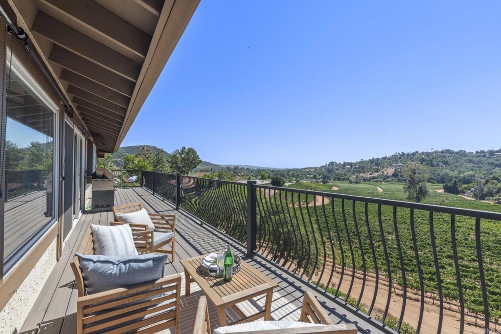 Incredible views and privacy! This feels like Napa Valley. Perched directly above and adjacent to the beautiful Monserate Winery Vineyard. Enjoy stunning sunset views from all of the major rooms in this lovely home as well as a spacious full-length balcony. This elegant and spacious 5 bedroom and 3.5 bath home has over 3800 sq ft and first-class amenities including a gourmet kitchen with Bosh appliances, self-closing Alderwood cabinets, granite counters, and Travertine floors. Enter the charming and entertaining gated brick front courtyard leading to the opening double door entry. Enjoy the dramatic living room and dining room with vaulted wood beam ceilings, separated by a beautiful double sided stacked stone fireplace, all with dramatic unobstructed views of the winery and surrounding hills of Gird Valley. There are three bedrooms on the entry level including a spacious master bedroom with gorgeous views, an elegant master bathroom, as well as an additional full bathroom and convenient half bathroom. Travertine and wood floors throughout. The lower level has a huge "great room" with a wet bar as well as two additional bedrooms, all with great views. You will also find a stunning bathroom, office space, and storage room on this floor. The separate entrance to the lower level opens up the possibility of multi-generational living. Popular Bonsall schools. Enjoy the views of the winery and visit the tasting room and restaurant. This is truly a unique private oasis in a great location close to Highway 76 and I-15. No HOA fees or Mello Roos tax.