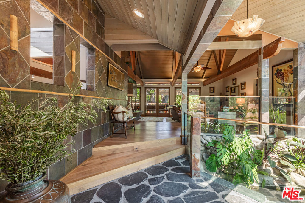 Welcome to 1064 Meadows End A One-of-a-Kind Architectural Sanctuary in Monte Nido's Coveted Malibu Canyon Neighborhood.Tucked at the end of a quiet cul-de-sac and framed by ancient sycamore and oak groves, this beautiful single-level architectural home offers a rare blend of refined design and natural beauty. Set on just over an acre of flat, park-like grounds, this property is a true staycation retreatprivate, peaceful, and surrounded by nature.Step through the serene entry with black flagstone pavers complete with a koi pond, and into an expansive, light-filled interior crafted with meticulous attention to detail. French Oak floors flow throughout, while dramatic wood-beamed ceilings and a striking four-sided fireplace anchor the open-concept living space. A wall of French doors seamlessly connects indoors to the entertainer's dream backyard, flooding the home with natural light and bringing the outside in.The chef's kitchen is a statement in both function and formfeaturing concrete countertops, top-tier appliances with double oven, warming drawer, ice machine, Sub Zero Refrigerator & Freezer, two dishwashers and custom cabinetry complete this fabulous kitchen. Skylights illuminate the adjacent dining area. A flexible floor plan offers 4 bedrooms, and 4 bathrooms ensures optimal privacy for guests, with well-separated secondary bedrooms. The newer primary suite is a sanctuary of its own, offering custom built-in cabinetry, soaring ceilings, French doors that welcome morning light, and a luxurious bath with a soaking tub and heated floors. A step-down family room leads out to a spectacular pool oasis designed by renowned landscape architect Nick Williams, complete with a rock waterfall and lushly landscaped surroundings. Back 4th bedroom could serve as additional den / office with oversized closet / art or hobby room. And unique rock wall 3/4 pool bathroom opens to outdoor shower and private garden.Wander through flowering gardens and along meandering paths beneath majestic oak trees. Enjoy a rose garden, fruit trees and charming chicken coop, and plenty of flat usable landperfect for outdoor entertaining, quiet reflection, or simply soaking in the beauty of this magical setting.Additional features include 3 tankless water heaters, Dual Zone HVAC system, new Generator 2024 and a new roof in 2025.Ideally located just minutes from Malibu Creek State Park's hiking trails, the vibrant restaurants, shops and beaches of Malibu. Calabasas Commons, and the 101 Freeway. Situated in the award-winning Las Virgenes School District, this is not just a homeit's a lifestyle.A rare architectural gem where nature meets design. A truly magical retreat.