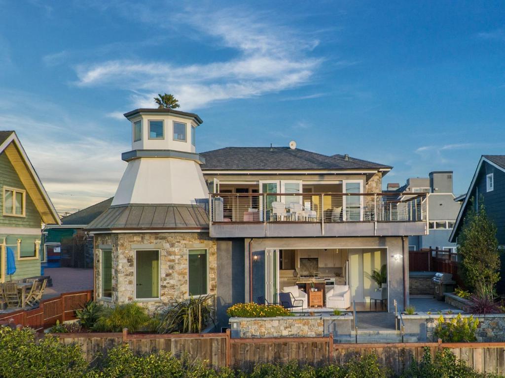 Designed for seamless indoor-outdoor living, expansive NanaWalls open to a wraparound stamped concrete deck, blending modern elegance w/coastal charm. The meticulously landscaped yard is an entertainers dream, featuring built-in planters, dual fire pits (gas and wood), a gas BBQ, a hot tub, & an outdoor shower that nods to the beach lifestyle. Expansive ocean views & 400 feet from Twin Lakes Beach, Inside, rich Brazilian teak (Cumaru) floors set a tone of warmth & sophistication. The gourmet chefs kitchen boasts top-tier appliances, a sprawling island, dual-drawer dishwashers, a wine fridge, a stand-alone ice maker, & a clever nook with water supply & drain for effortless hosting. Upstairs: via stairs or the three-floor elevator, the primary suite is a sanctuary w/a spa-inspired ensuite & private balcony showcasing jaw-dropping views. There is a hidden passage behind built-in shelves that reveal a turret w/a telescope, perfect for stargazing or soaking in Lighthouse Point vistas. The upper deck, w/teak panels, elevates the luxury. The lower level offers a media room, recreation space, office, & a guest-ready bathroom w/a second laundry. Parking for five vehicles & fire sprinklers for peace of mind, every detail has been considered. This is more than a home, its a lifestyle!
