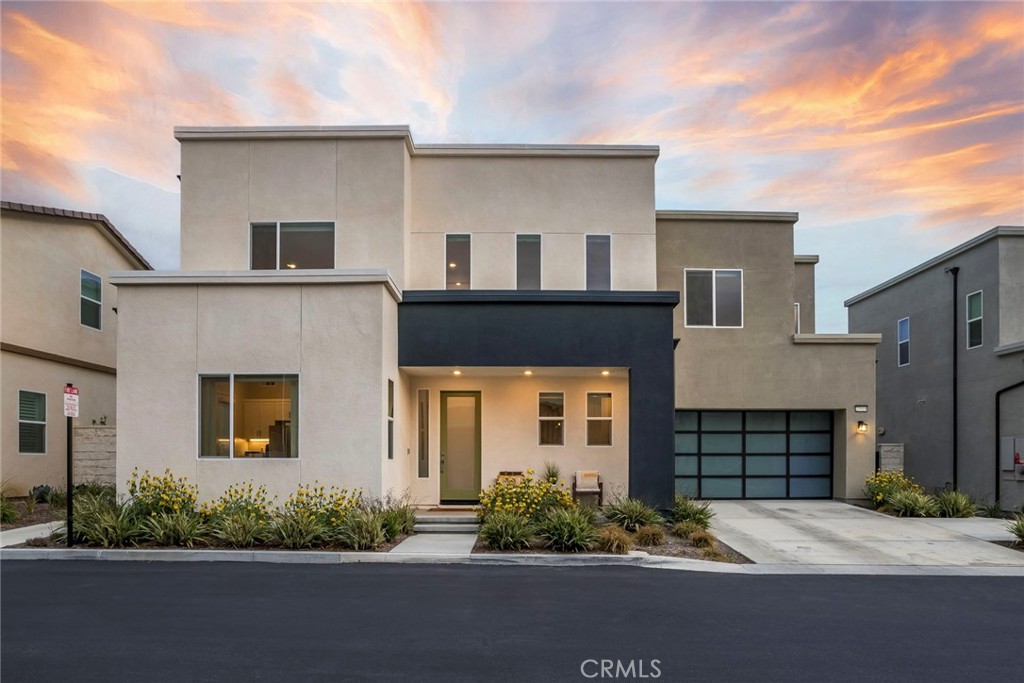 Discover this beautifully upgraded home located in the sought-after Wisteria neighborhood. Offering 4 bedrooms and 5 bathrooms, this residence includes a versatile "NEXT GEN" suite (or attached ADU) with a private entrance, full bath, and dedicated laundry—ideal for guests or multigenerational living. Enjoy nearly 3,600 sq. ft. of thoughtfully designed open-concept living, featuring inviting paint selections, designer lighting, wide plank flooring in Bedford Oak throughout the main areas, recessed lighting, and expansive windows that flood the space with natural light. The chef’s kitchen is equipped with white shaker cabinetry, professional-grade stainless appliances, built-in refrigerator, quartz countertops, a statement backsplash, and an oversized island with seating for four. The adjoining great room offers ample space for entertaining and views of the meticulously designed backyard. Upstairs, soft Shaw carpeting, large windows, and streamlined window treatments create a warm and refined atmosphere. The primary suite includes panoramic neighborhood views, a spacious walk-in closet, and a luxurious ensuite with a walk-in shower, dual quartz vanities, and a freestanding soaking tub. Two additional generously sized bedrooms, a large loft, two bathrooms, and a laundry room with extensive storage and counter space complete the upper level. Outside, the oversized premium lot is professionally landscaped with low-maintenance, drought-resistant greenery, artificial turf, and elegant hardscaping. Additional modern features include OWNED solar, a tankless water heater, and a commercial-grade Wi-Fi network for optimal connectivity. Residents enjoy exclusive access to HOA amenities such as a clubhouse, pool, spa, community garden, and playground. Conveniently located near top-rated schools, shopping, dining, and the 5 freeway.