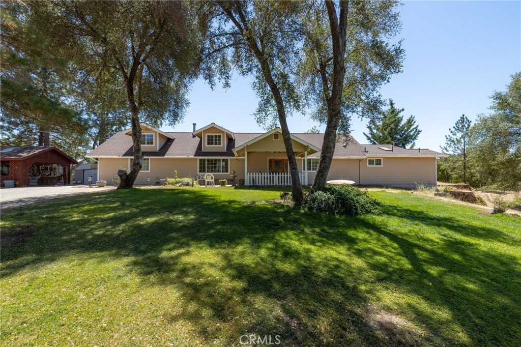 Custom 4 Bedroom Home in Scenic Ahwahnee with Horse Potential & Oversized Detached Garage
Discover this beautifully appointed 3,007± sq. ft. custom home nestled in the tranquil foothills of Ahwahnee, California. This spacious 4 bedroom, 3 bathroom residence sits on a thoughtfully maintained lot with horse ownership potential, manicured landscaping, and a concrete driveway leading to an oversized detached garage and additional outbuildings.
Step inside to a warm and inviting interior featuring soaring pine wood ceilings, strategic skylights, and an open-concept living area that flows seamlessly into a chef-inspired kitchen—perfect for entertaining. The formal dining room is ideal for memorable gatherings, and a versatile library or office space offers quiet productivity.
The primary suite is a private retreat with a walk-in closet and spa-like bathroom with a walk-in shower. The intelligent split-bedroom layout ensures privacy for all. Outdoor living is just as appealing, with a welcoming patio and covered front porch ideal for relaxing and enjoying the peaceful surroundings.
Additional highlights:
* Concrete hardscaping for easy maintenance, RV hook-ups
* Oversized detached garage + outbuildings for storage/workspace
* Located near Yosemite National Park, Bass Lake, and Oakhurst!
This move-in ready home offers a perfect blend of thoughtful design, comfort, and convenience in one of the Sierra Foothills’ most desirable communities.
